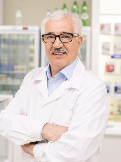 aged-drugstore-worker-in-whitecoat-and-eyeglasses-crossing-his-arms-by-chest-e1634020513496.jpg